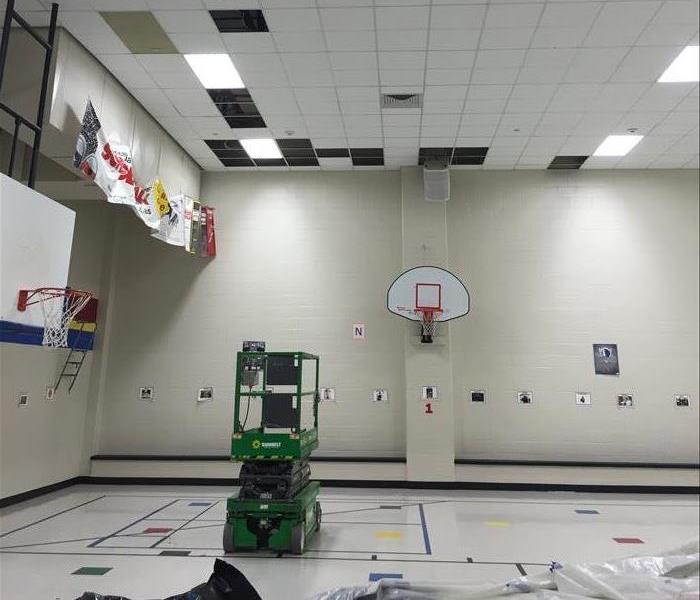 A large school gym being prepped for mitigation work after a flood.