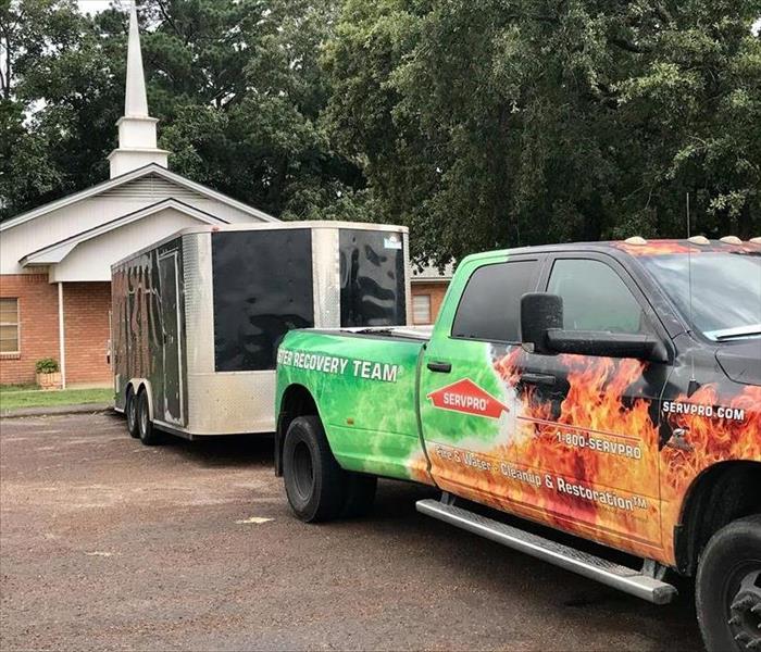 A SERVPRO truck in front of a small church