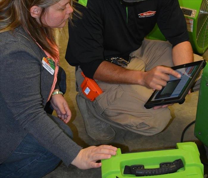Two SERVPRO technicians going over materials on site.