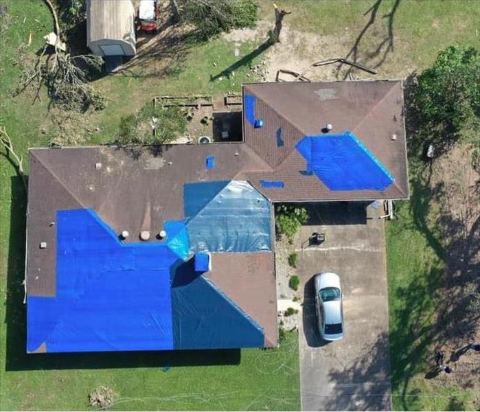 Houses with blue tarps after storm damage in lufkin texas